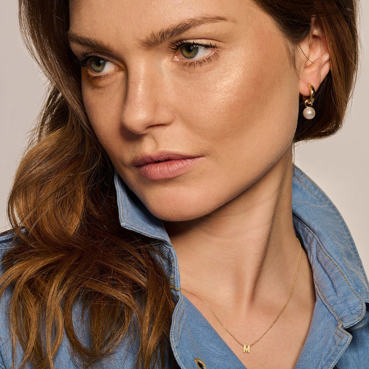 Livia Pearl Earrings in gold, shown on the model