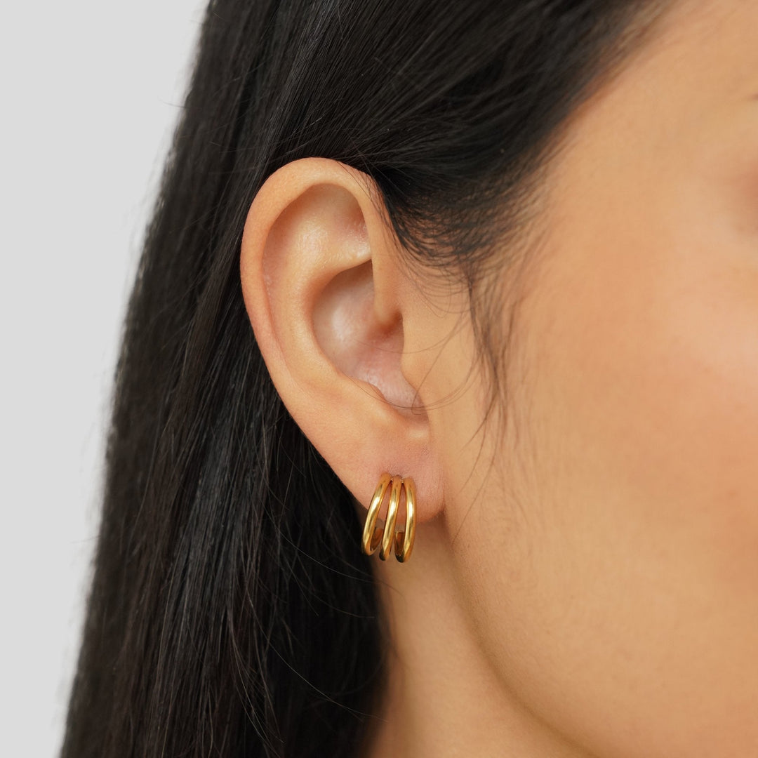 Rani Earrings in gold, close-up on the ear